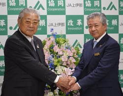 固く握手を交わす西村組合長（右）と御子柴前組合長
