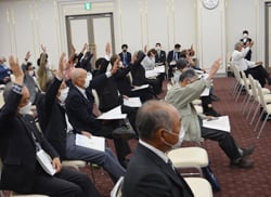 議案に対し挙手で賛成する総代会の様子