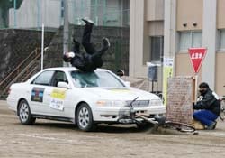 自動車の死角から飛び出した自転車が事故に遭う瞬間を再現したスタント