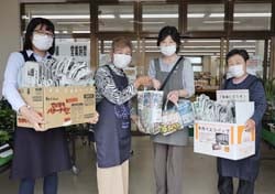 利用客（右から2番目）にエコバックを手渡す部員（長野県岡谷市で）