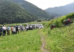 ラジコン草刈り機の実演を見学する組合生産者ら
