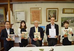 五平餅を提供した鈴木社長（中央）と中村理事（右）受け取った小出校長（右から2人目）
