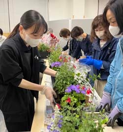 講師（左）から教わりながら寄せ植えを楽しむ参加者