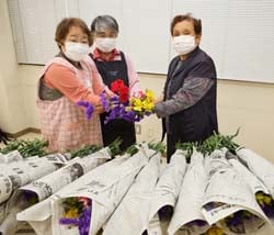 部員に花束を手渡す花岡ブロック長（左）ら