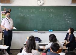 児童を前に郷土料理や管内の農産物について説明する折井課長と植松係長