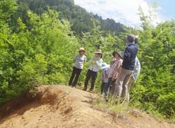 栄村地震により山の一部が崩れた様子を見る部員ら