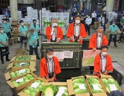 セリ台に立ってトップセールスをする田屋組合長（左）、原木曽町長（中）、唐澤木祖村長（右）