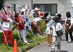 名物のかかしを眺める来場者