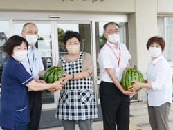 同施設の職員にすいかを手渡す女性部員