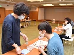 講師に模様の貼り付けポイントを聞く受講生