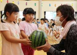 園児にスイカを手渡す中平後継営農部長（右）