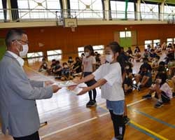 守谷理事から「ちゃぐりん」を受け取る児童