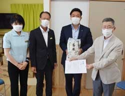 米を提供した白鳥常務（中央左）と宮下会長（右）