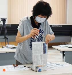 エコバッグの持ち手をのり付けする参加者