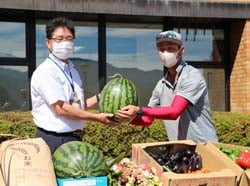 特産品のスイカを手渡す太田洋道支部長（右）