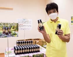 「ブルーベリーフルーツピクルス」を持つ北嶋事務長