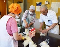 もち麦の袋詰めを行う組合員