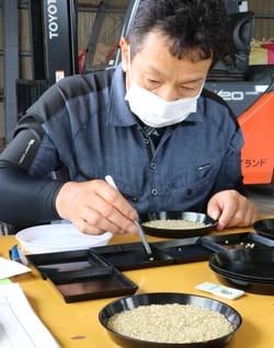 新米の品質を入念に確認する検査員