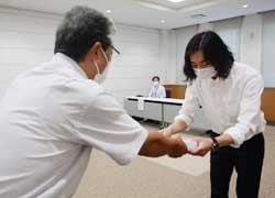 田中組合長（左）から認定書を受ける樋口さん