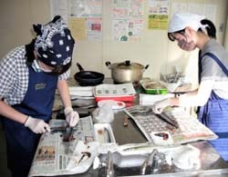 サンマの三枚おろしに挑戦する参加者