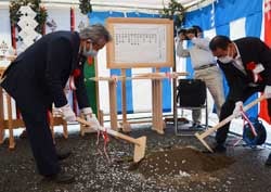 安全祈願祭で鍬入れの儀を行う西村組合長（左）と山崎社長
