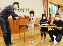 園児に新鮮な野菜を手渡す部員