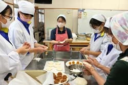 包み方の指導を受ける生徒