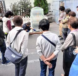 硫黄燻蒸を見学する参加者