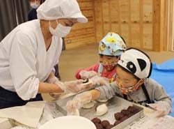 講師とともに粉からつくった生地へあんこを乗せる参加者
