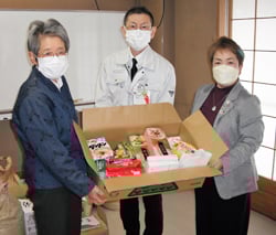山宮センター長（中央）に食品などを手渡す武捨支会長（左）と久保支会長（右）