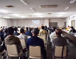 産地拡大プロジェクトについて説明を受ける生産者（伊那市狐島で）
