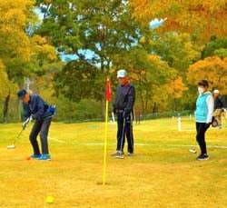 紅葉の中でマレットゴルフを楽しむ参加者