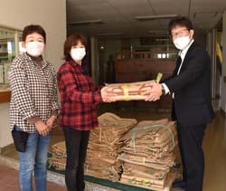 空き袋を手渡す今牧支部長（写真中央）