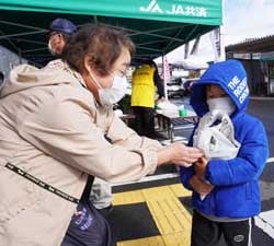 あつあつの焼き芋を手渡す花岡さん（左）