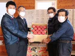 りんごを手渡す倉橋副支部長（右から2番目）と唐沢英彦副部会長（右）