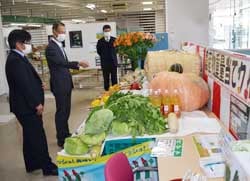 農産物を見ながら意見を交わす白鳥常務（中央）と古畑代表運営委員（左）