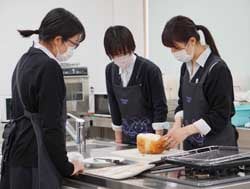 焼き上がったお米パンを切り分けるJA職員