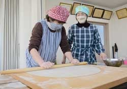 そば打ちを教えあいつつ、楽しむ参加者（7日　松本市で）