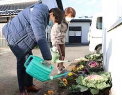 協力して植えた花に水をあげる部員と職員（左）（1日、松本市にて）