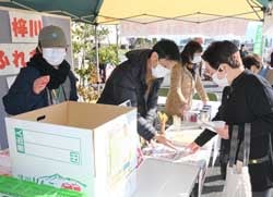 大抽選会で組合員（右）にくじの内容を説明するJA職員（左から2人目）