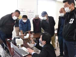 機械の実演を見て使用方法を確認する青壮年部員