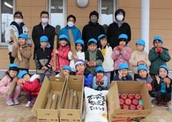真っ赤なりんごとでっかいナガイモに笑顔の園児ら（13日　山形村で）