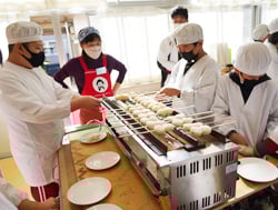 五平餅の焼き色を確認する児童