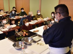 包丁捌きの実演を間近で見る受講生