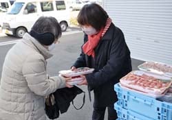一人ひとりに地元産豚肉を手渡した年に1度の販売会