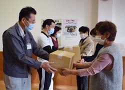 施設代表者（左）へタオルを手渡す様子