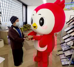 ゆめピーちゃんから記念品を受け取る来店者