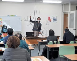 リンゴの枝を使って説明する坂口技術員
