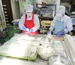 餅を手早くパックに詰める加工部員