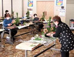 正月向けフラワーアレンジメント作りに挑戦する参加者